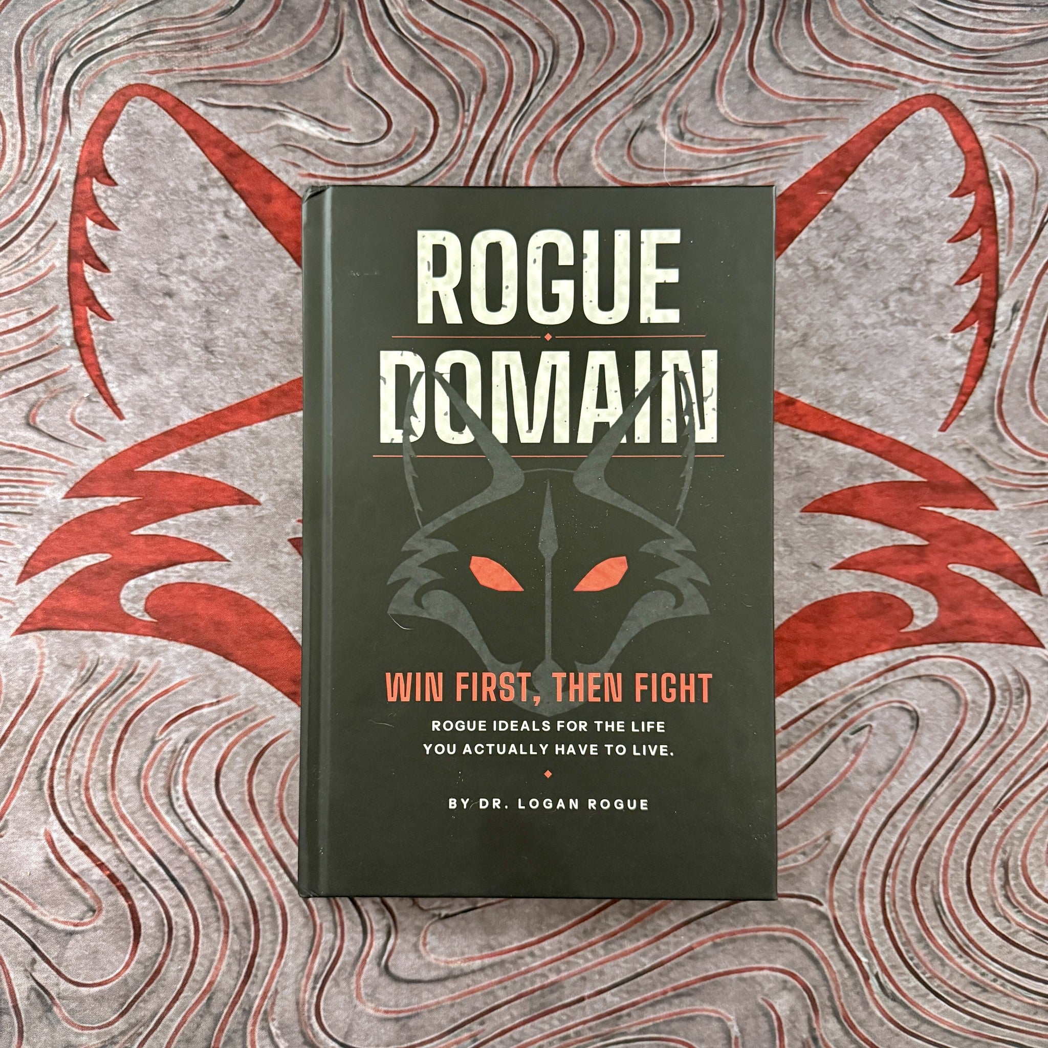 Rogue Domain: Win First, Then Fight signed hardcover by Dr. Logan Rogue on a red fox print background