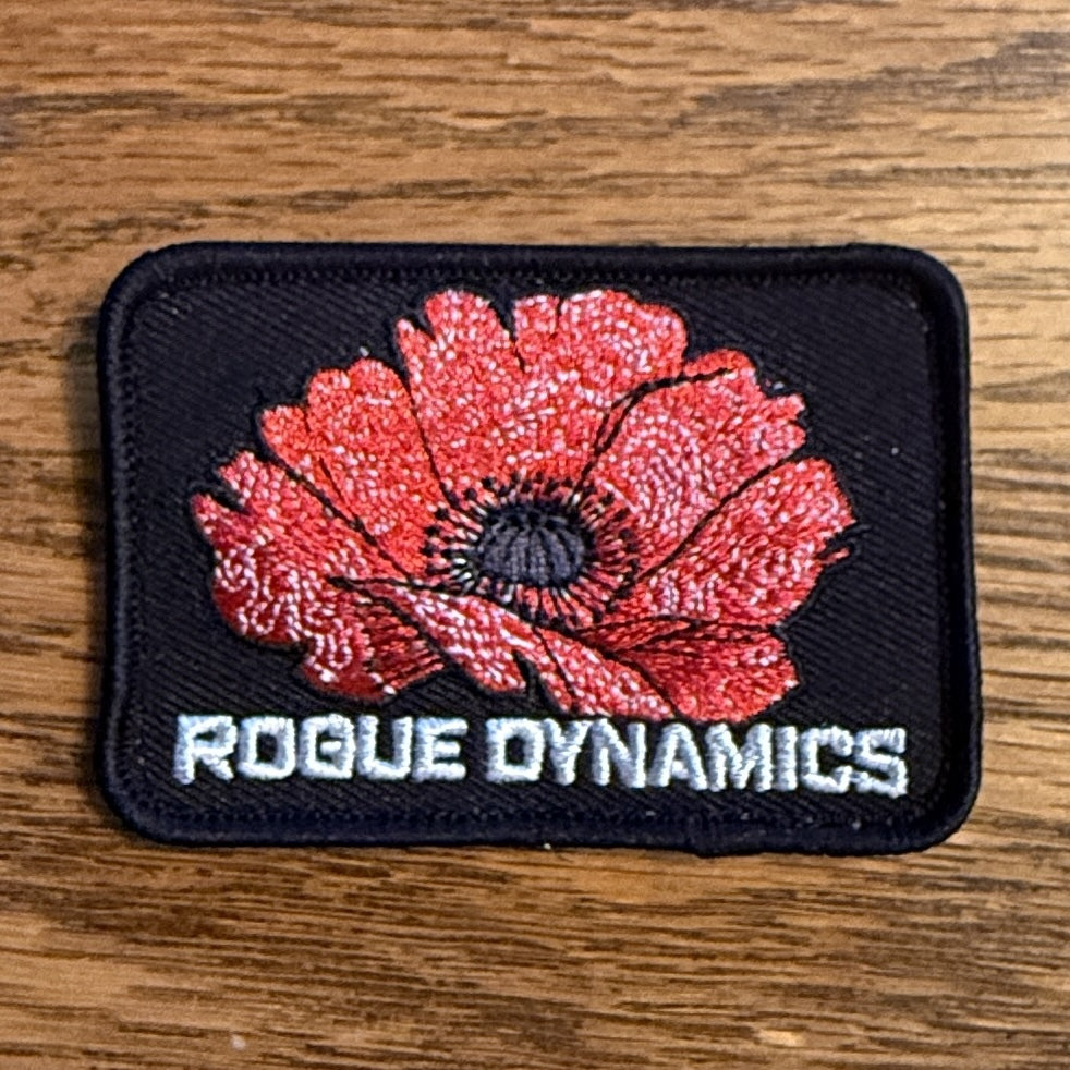 Rogue Dynamics embroidered red poppy remembrance patch on black twill, angled view